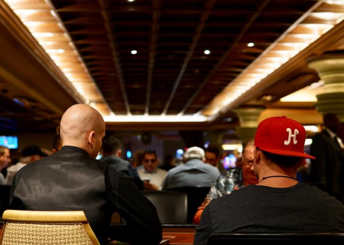 man in black crew neck shirt wearing red cap sitting on chair